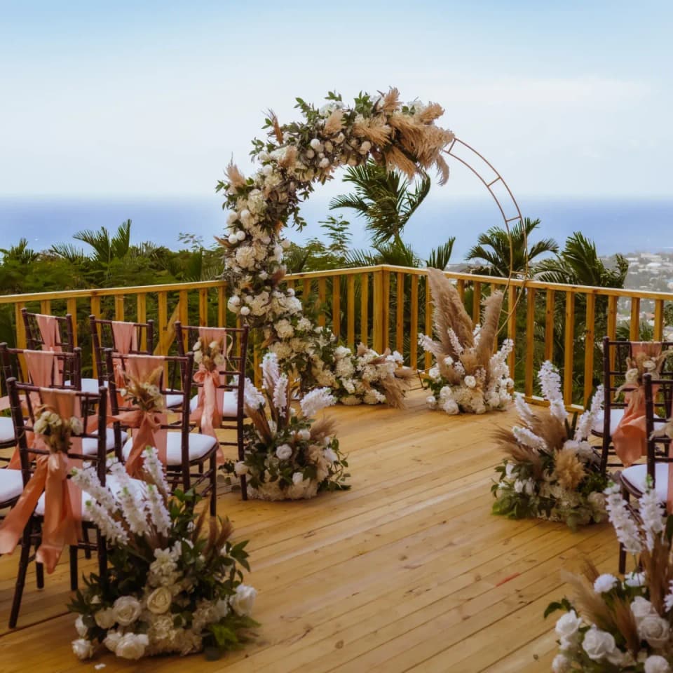 A floral arch on the deck at Bay Vista Villa with the bay of Ocho Rios behind it