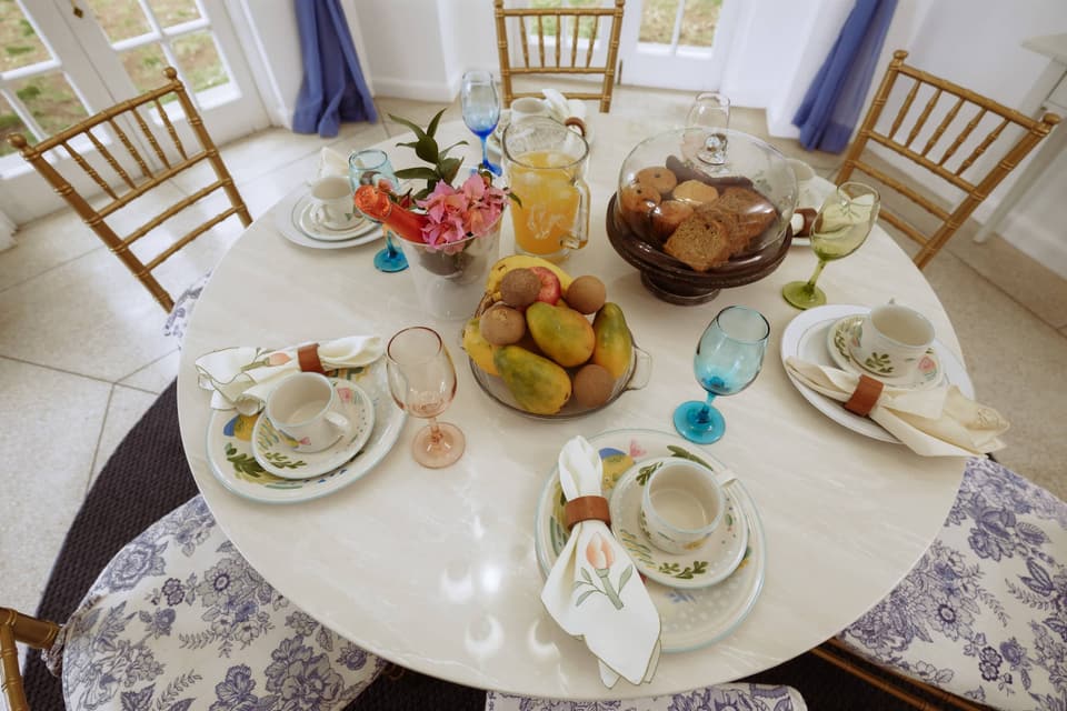 Breakfast laid on the round table at Bay Vista Villa: fresh fruit, bread and juice