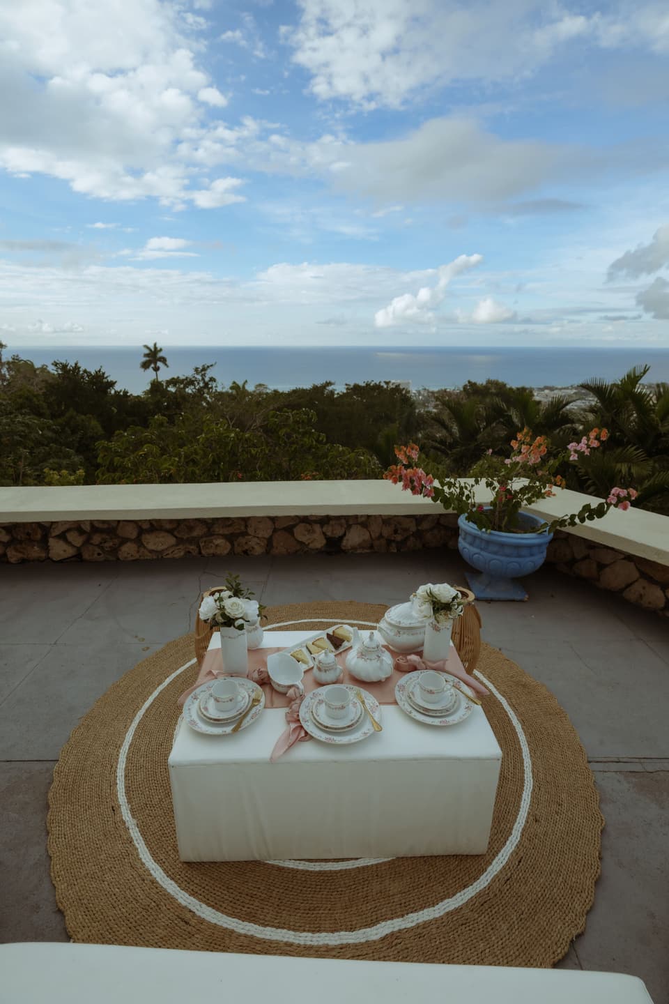 A tea table laid on the stone terrace at Bay Vista Villa with the coastline of Ocho Rios beyond